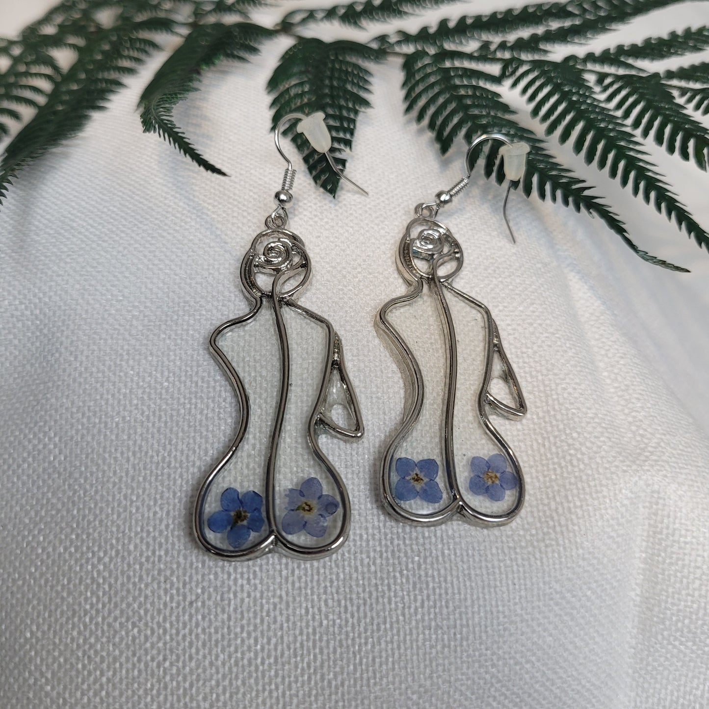 Silver colour floral bust and figure earrings