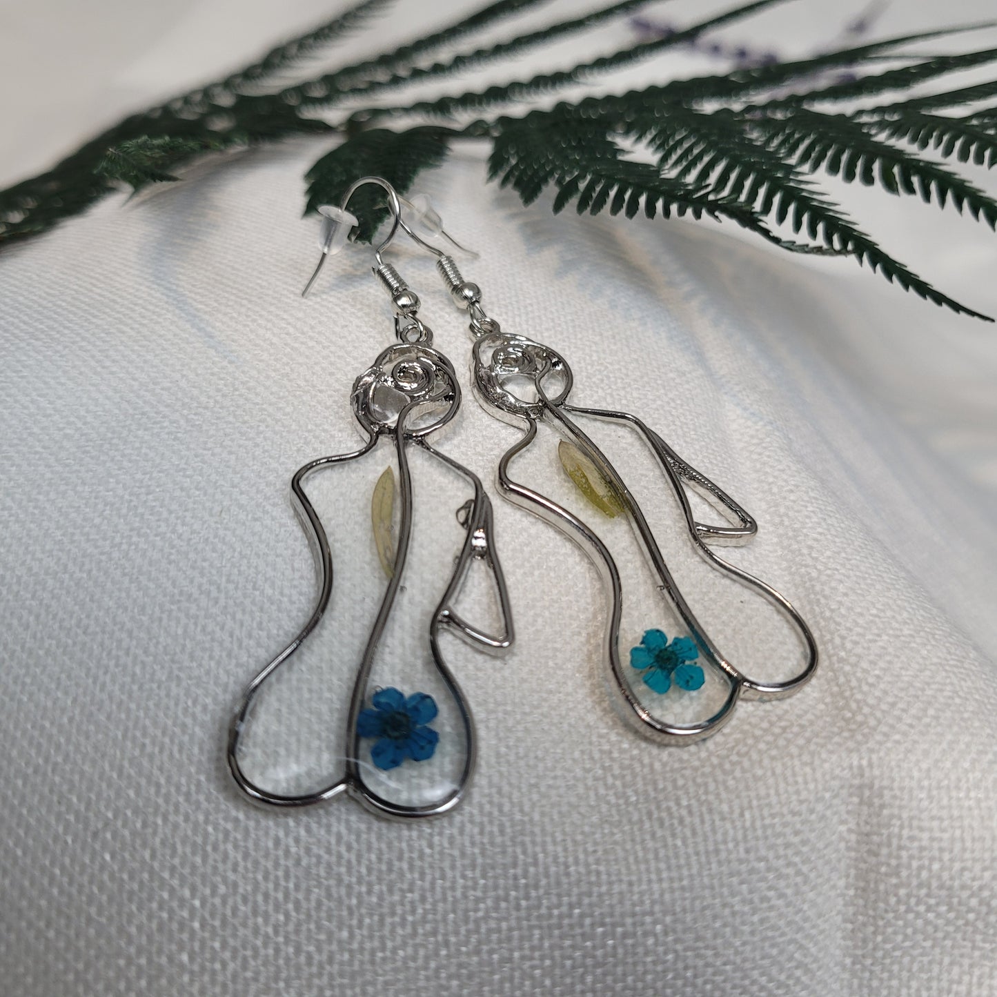 Silver colour floral bust and figure earrings