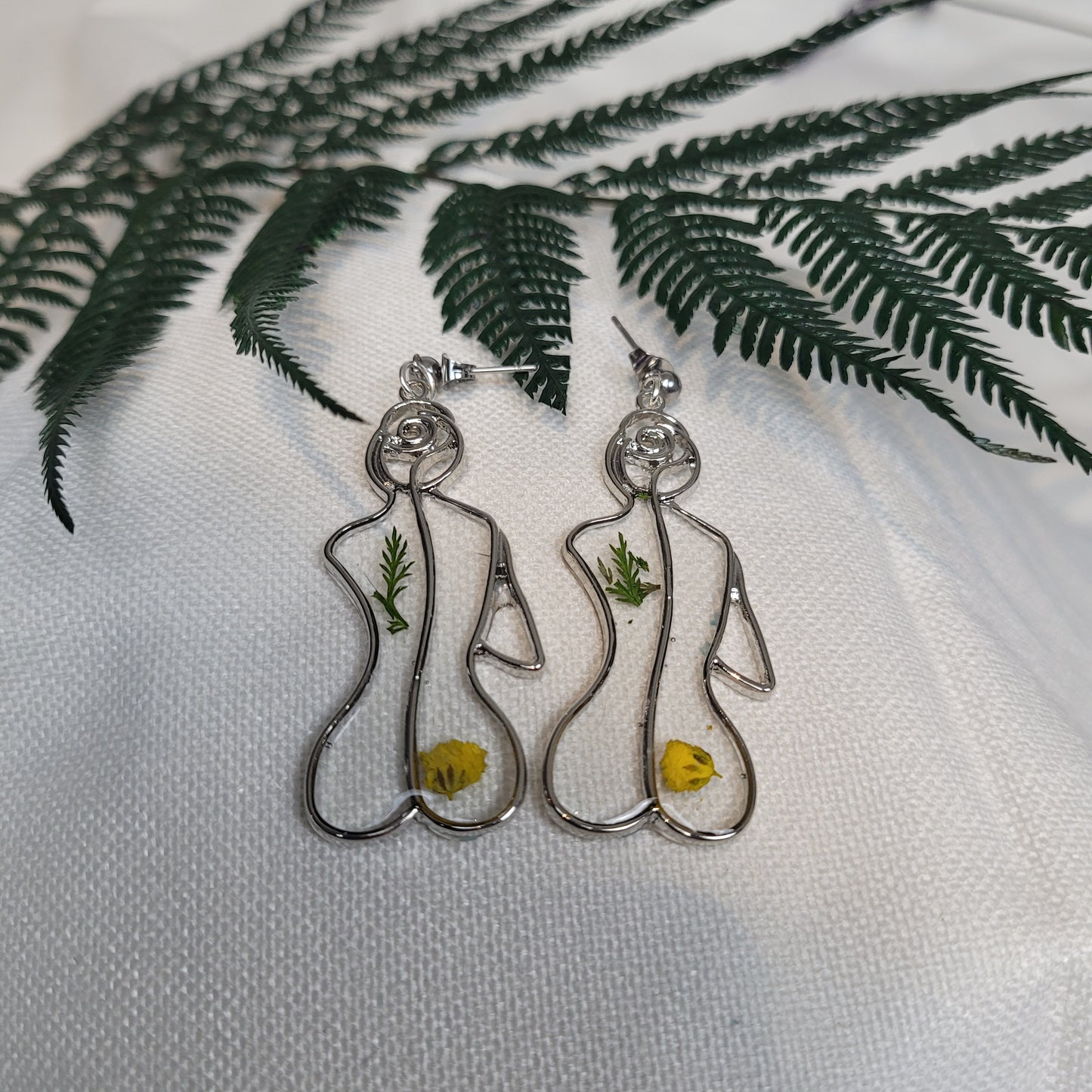 Silver colour floral bust and figure earrings