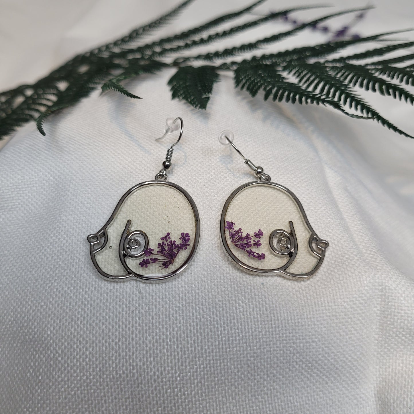 Silver colour floral bust and figure earrings