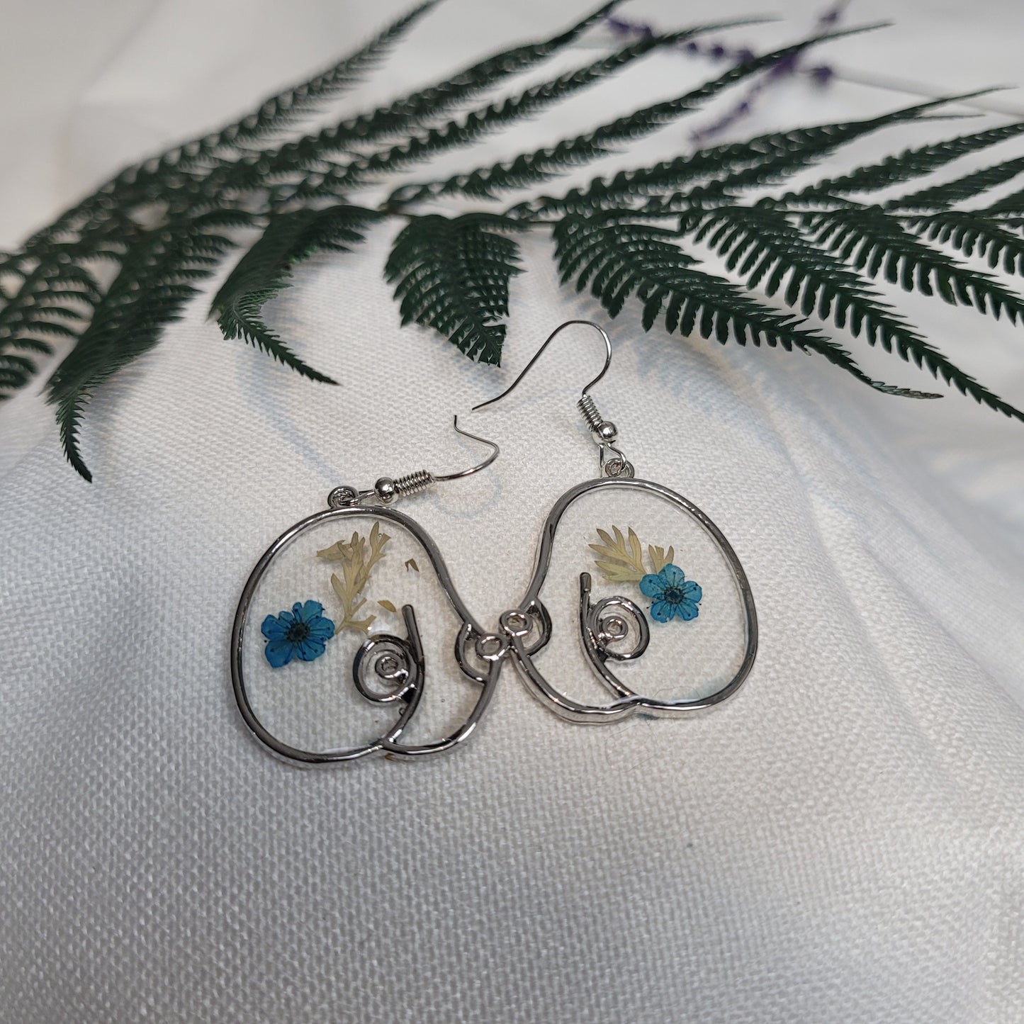 Silver colour floral bust and figure earrings
